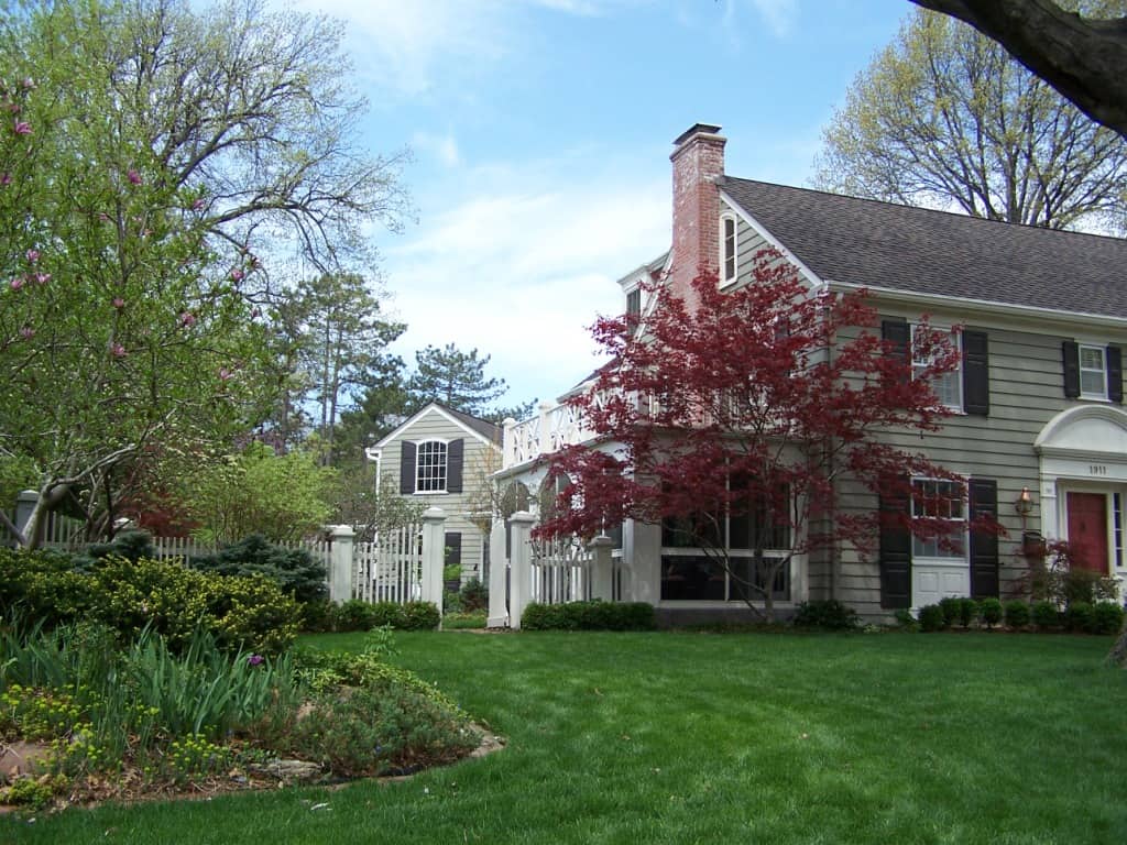 The sweeping curves, tall trees, and large planting beds fit the scale of this house.