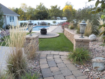 Poolside plantings, patio, and fire pit separate this landscape into several rooms.