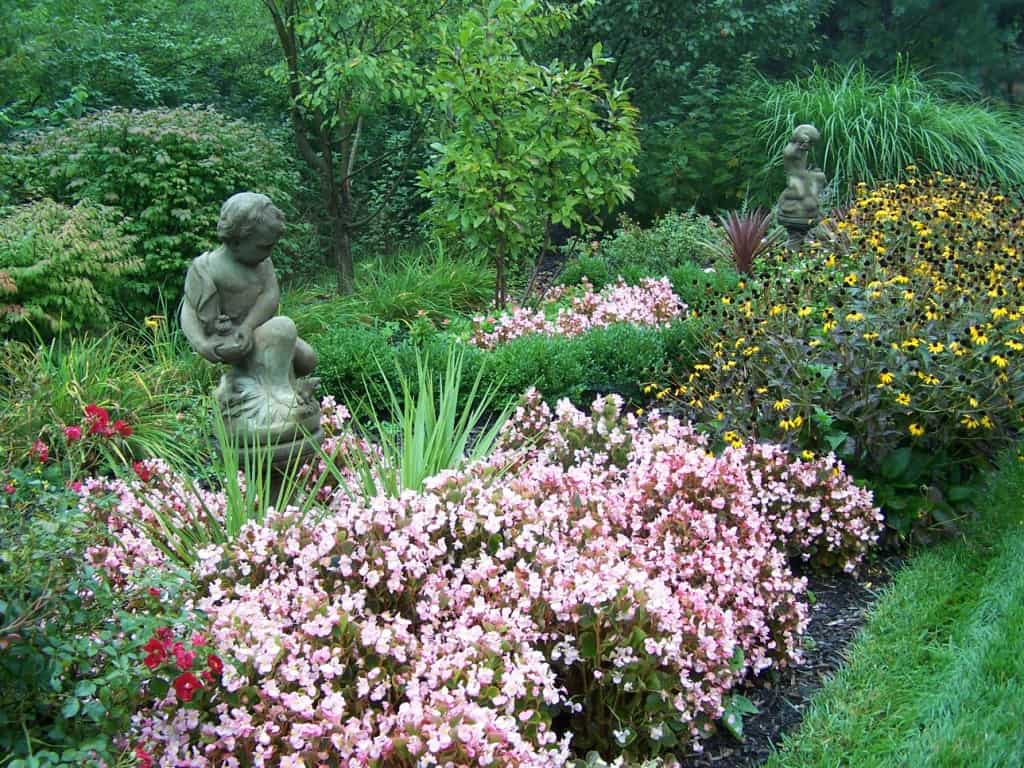 Massing plants around garden statuary is romantic/artistic